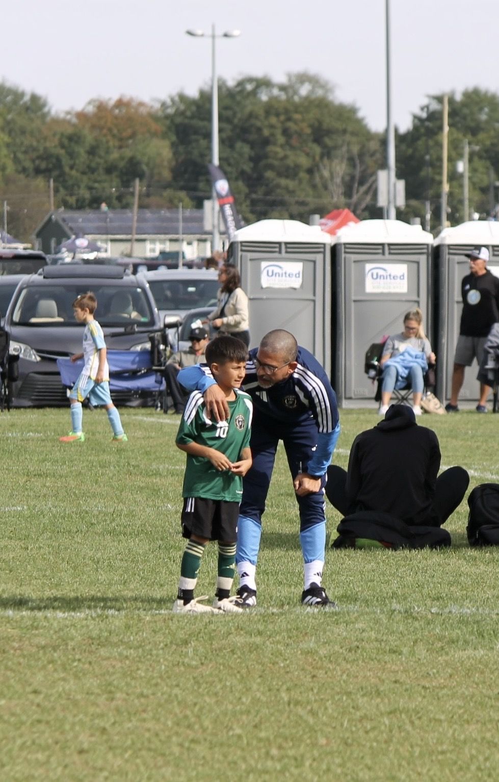 Coach Khaled with a U8 player during a game